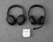 Over-ear headphones, a boom-microphone headset, and wireless earbuds arranged on a desk.